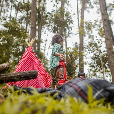 Kind im Wald mit Laterne, Decke auf dem Boden und Kinder-Tipi-Zelt
