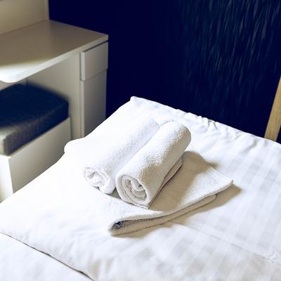 Handtücher zusammengerollt auf Bett